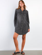 Woman wearing a black denim dress against a white background
