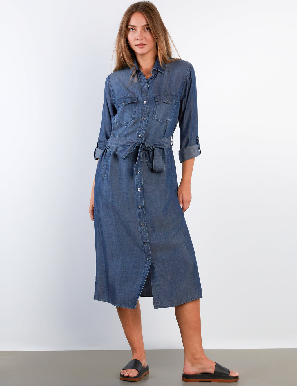 Woman wearing a blue denim dress against a white background